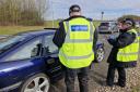 Officers speaking to a driver at a checkpoint