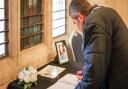 Members of the public sign the book of condolences, located in Saffron Walden Town Hall.