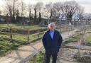 Cllr Geoffrey Sell next to the unfinished allotments and playground in Stansted Mountfitchet