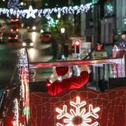 Santa in his sleigh passes under the Christmas lights on the High Street, Saffron Walden